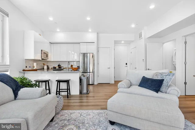 a living room with furniture and kitchen view