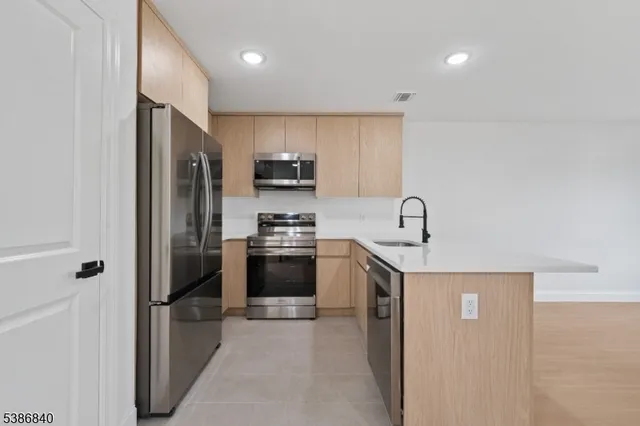 a kitchen with stainless steel appliances a refrigerator stove and sink