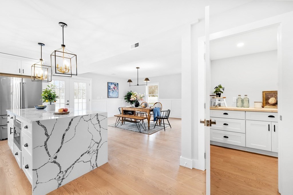 20 Mohawk Road Burlington, MA 01803 - Photo 12 of 39 a living room with furniture and a dining table with wooden floor