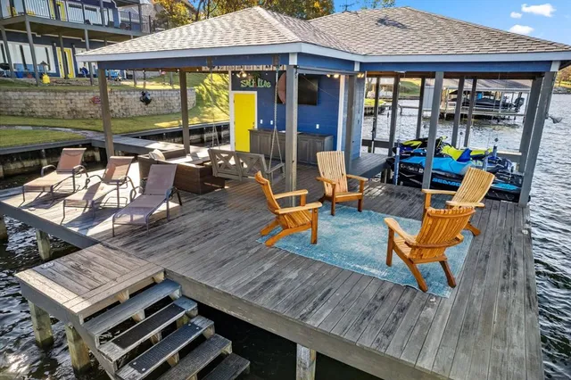 a view of a patio with table and chairs barbeque potted plants and large tree