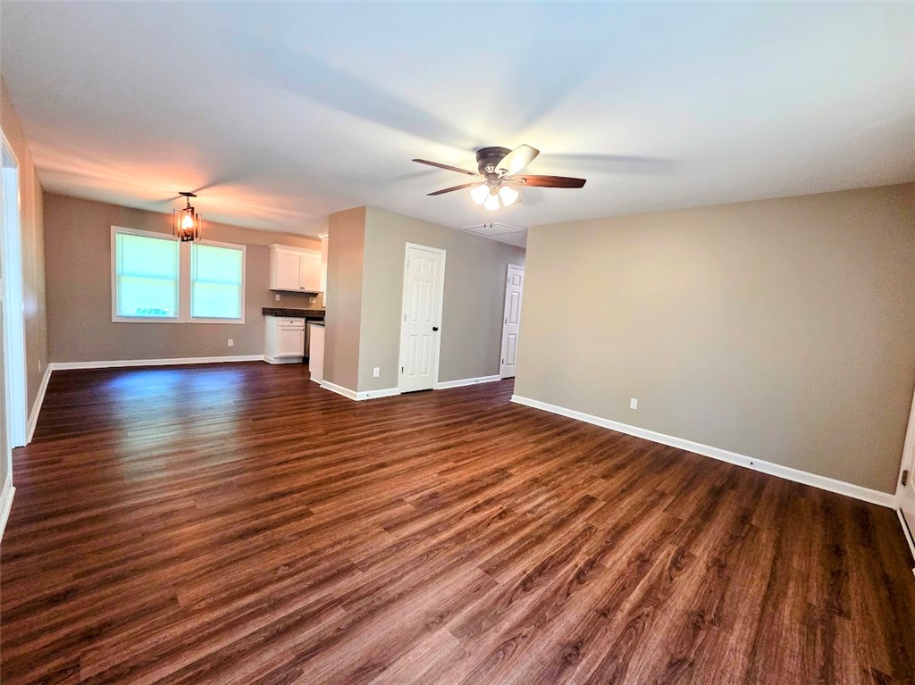 509 Elrod Road Piedmont, SC 29673 - Photo 5 of 28 Rich hardwood floors flow through this open-concept space, extending to the compact yet efficient kitchen area.