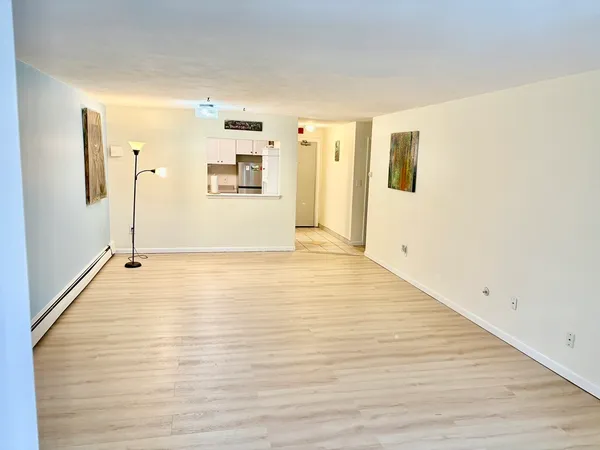 a view of a big room with wooden floor and windows