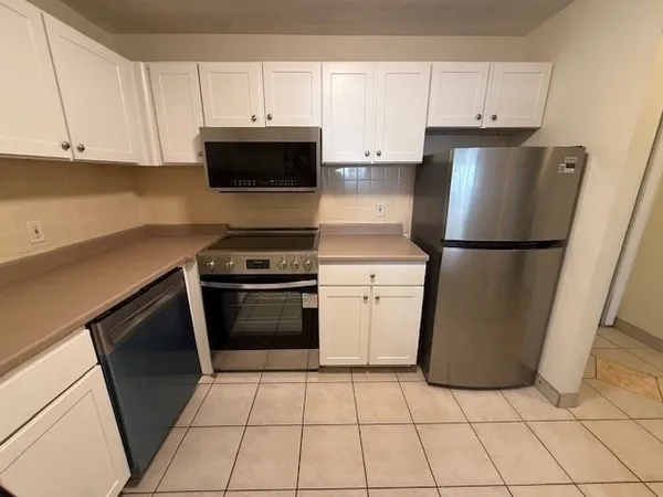 a kitchen with a sink a stove and cabinets