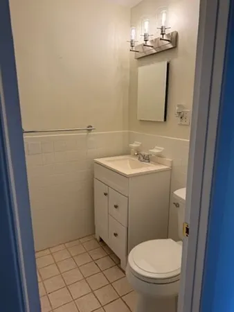 a bathroom with a toilet sink and mirror