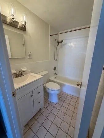 a bathroom with a granite countertop sink toilet a mirror and shower