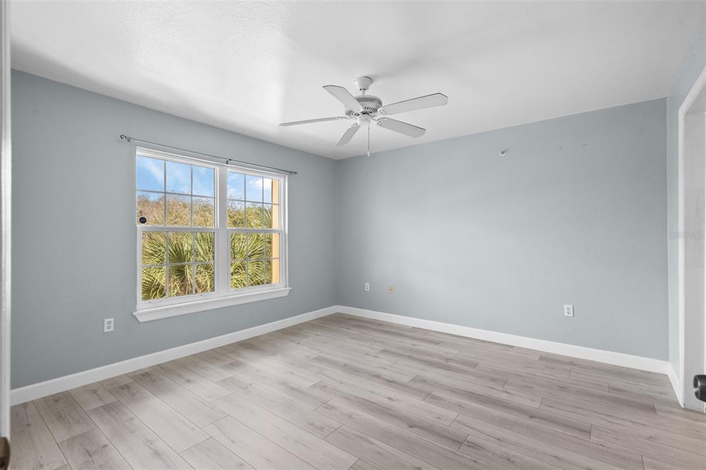 5459 Vineland Road, Unit 4302 Orlando, FL 32811 - Photo 12 of 25 an empty room with wooden floor ceiling fan and windows