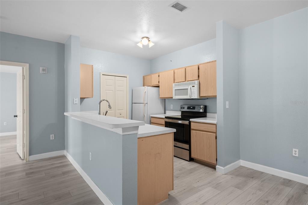 5459 Vineland Road, Unit 4302 Orlando, FL 32811 - Photo 2 of 25 a kitchen with stainless steel appliances granite countertop a sink stove and refrigerator