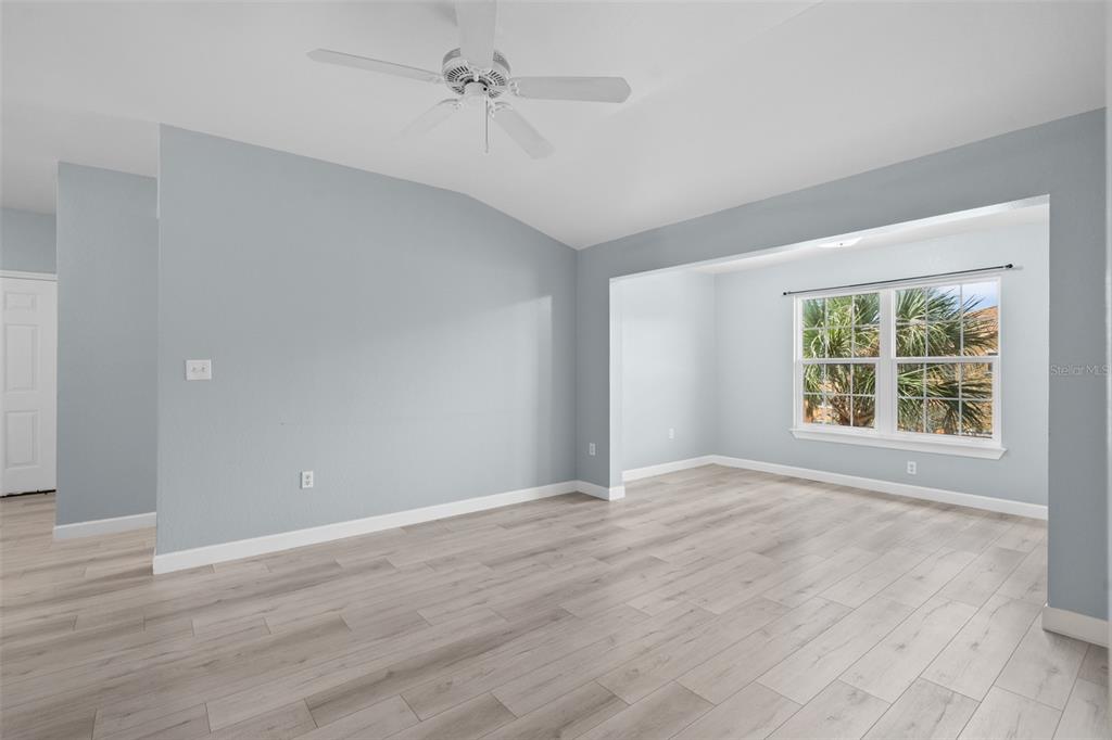 5459 Vineland Road, Unit 4302 Orlando, FL 32811 - Photo 9 of 25 a view of an empty room with wooden floor and a window