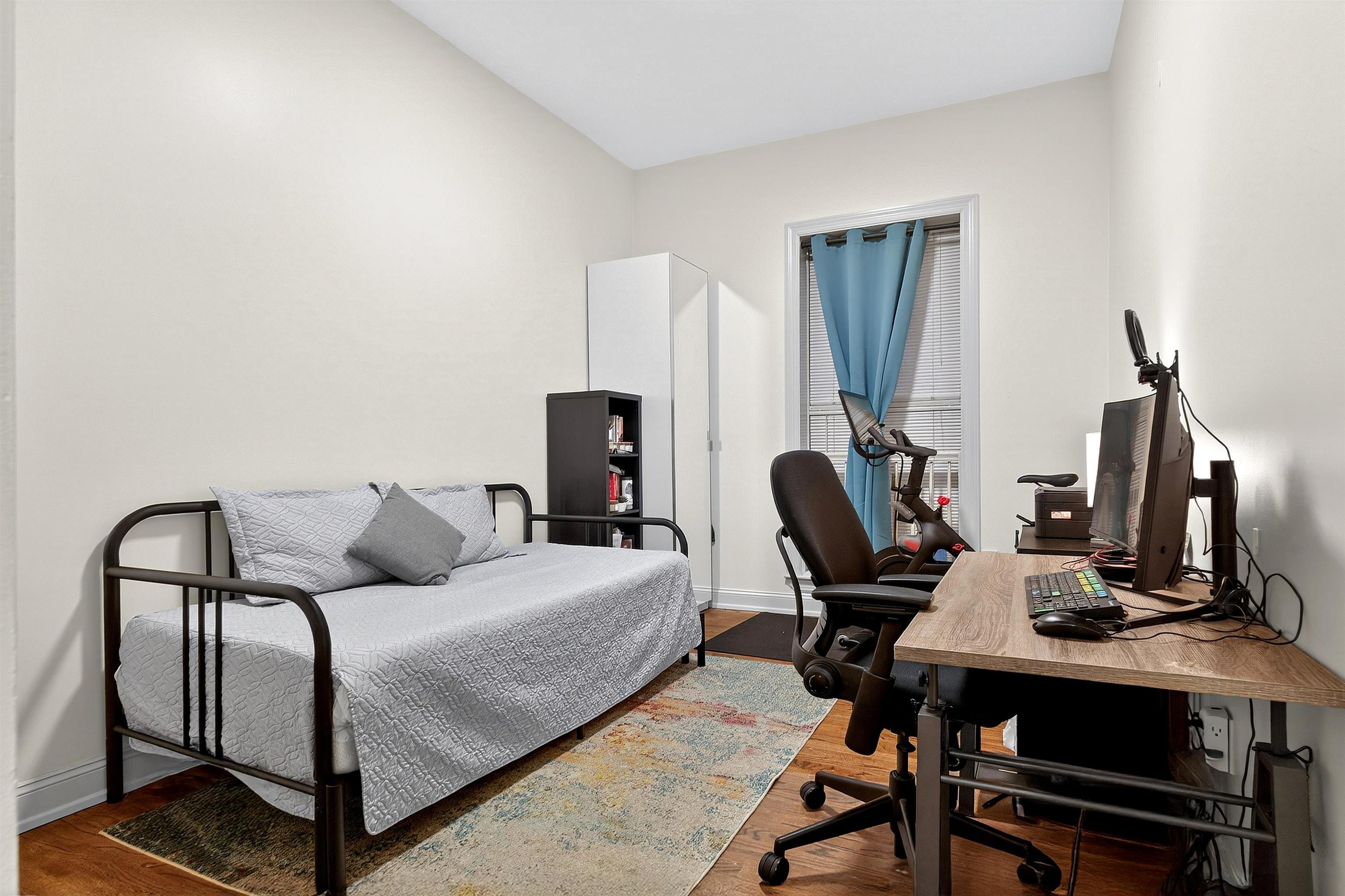 46 Mercer Street, Unit 2 Jersey City, NJ 07302 - Photo 13 of 17 a bedroom with a bed and a computer on a desk