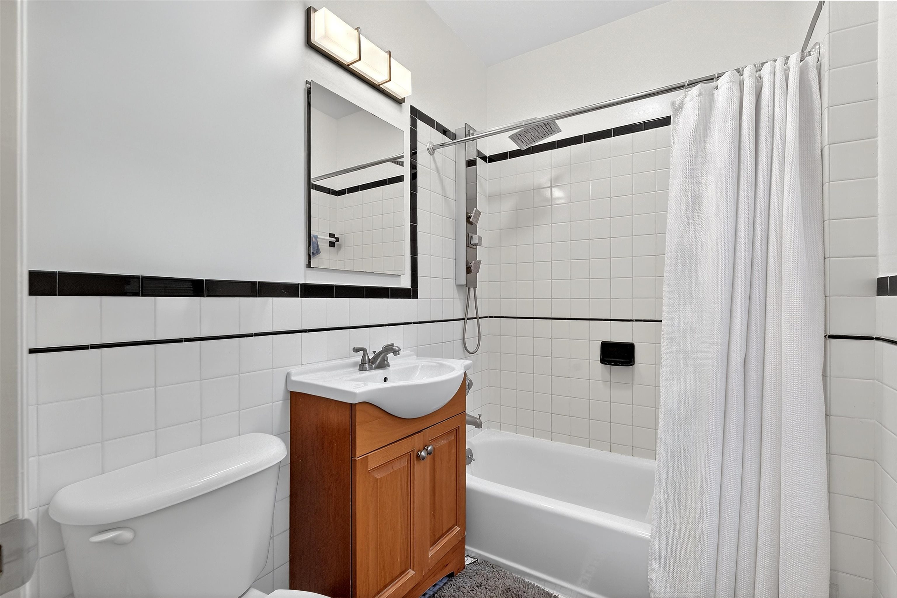 46 Mercer Street, Unit 2 Jersey City, NJ 07302 - Photo 14 of 17 a bathroom with a sink a toilet and shower