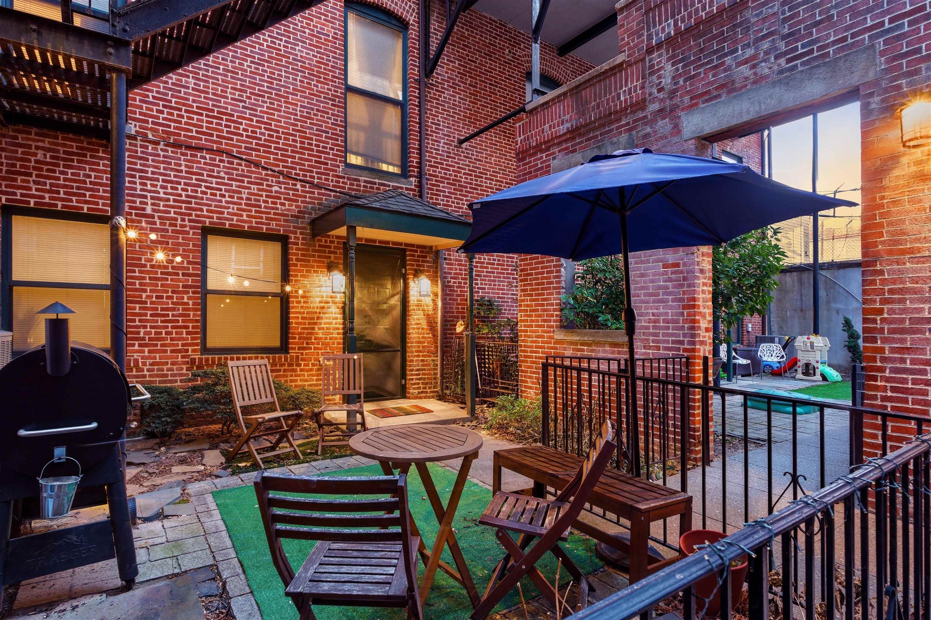 46 Mercer Street, Unit 2 Jersey City, NJ 07302 - Photo 3 of 17 a view of a patio with a table and chairs under an umbrella