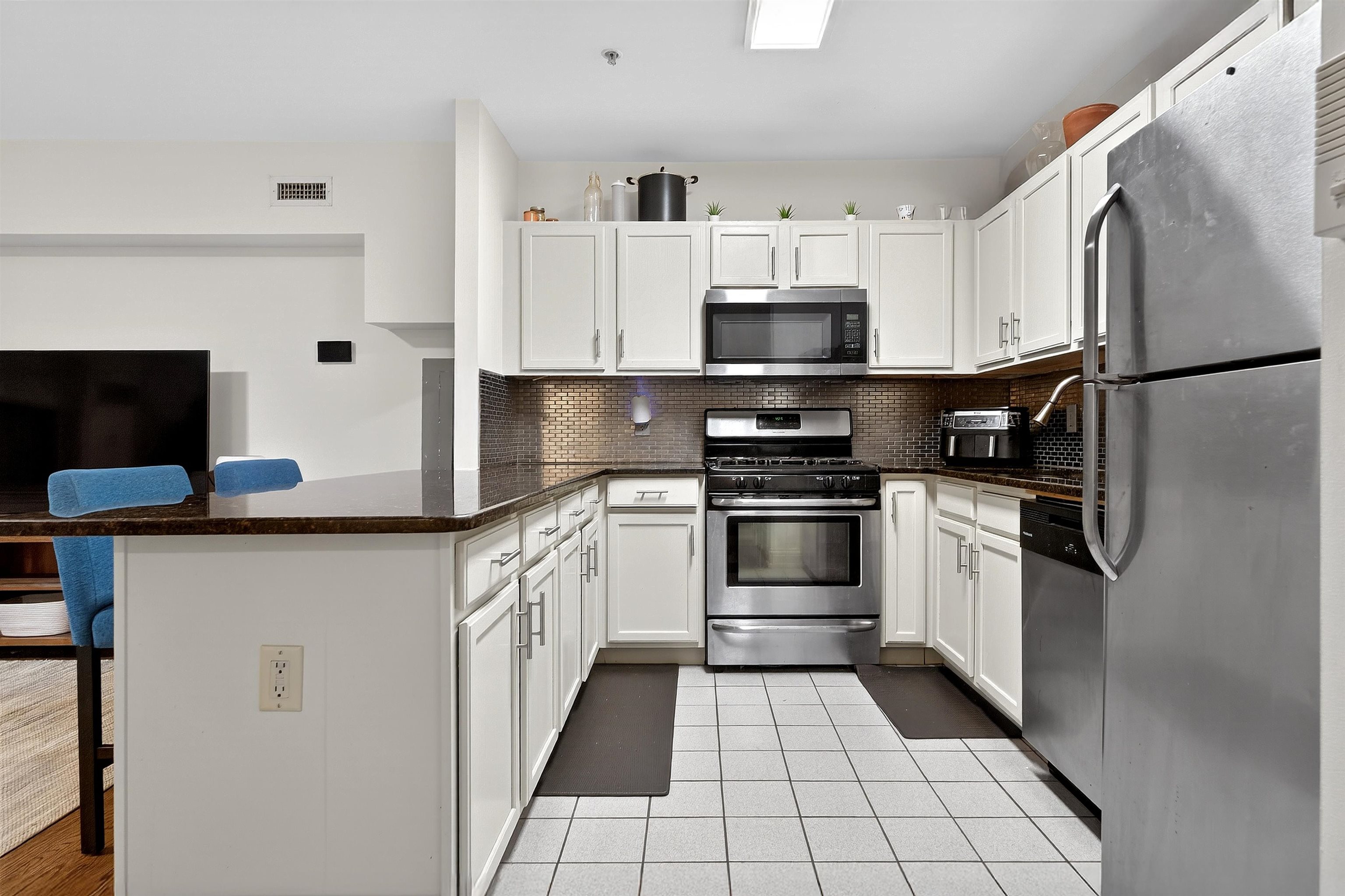 46 Mercer Street, Unit 2 Jersey City, NJ 07302 - Photo 6 of 17 a kitchen with stainless steel appliances a refrigerator sink and stove top oven
