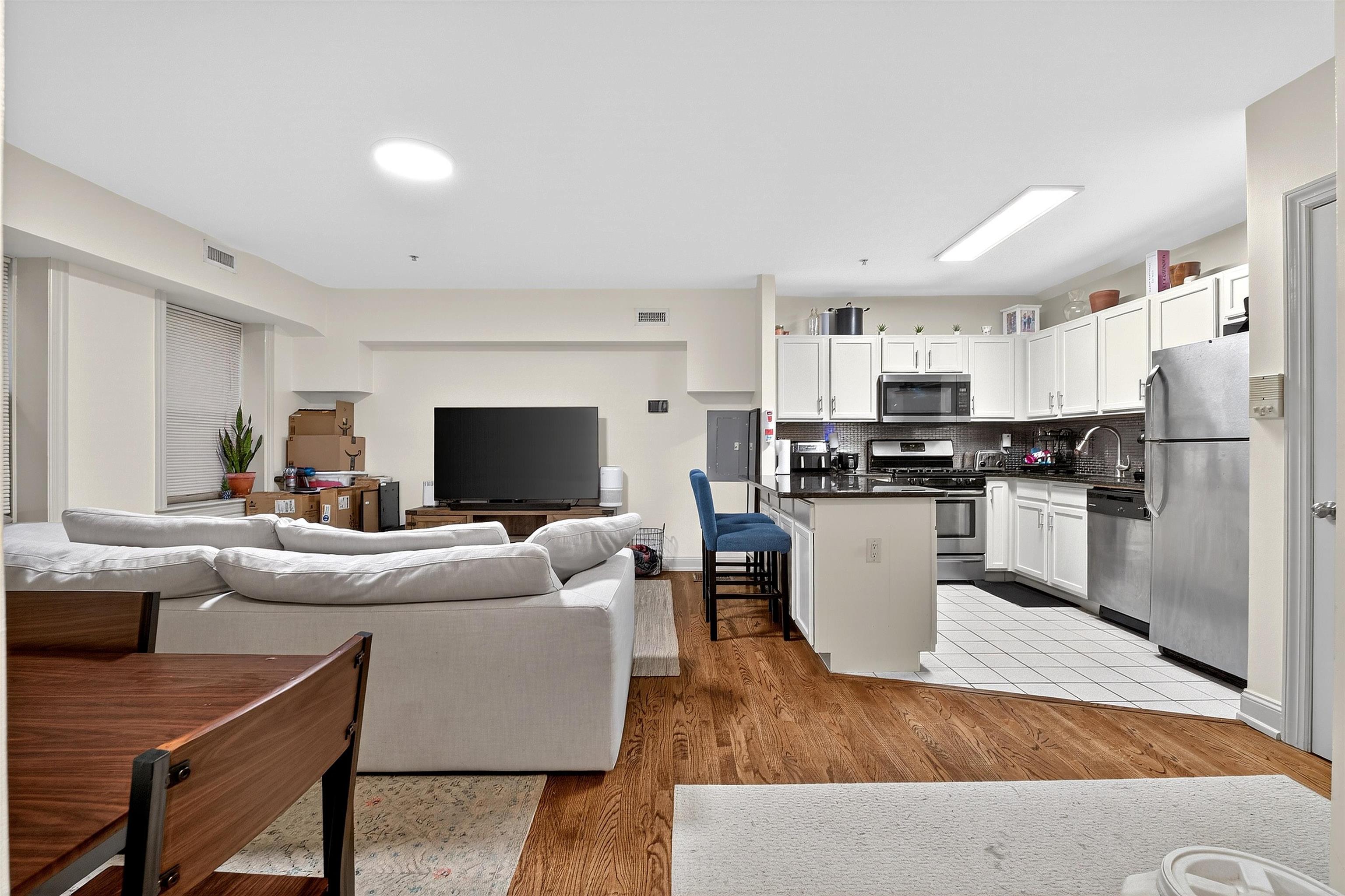 46 Mercer Street, Unit 2 Jersey City, NJ 07302 - Photo 7 of 17 a living room with stainless steel appliances furniture and a kitchen
