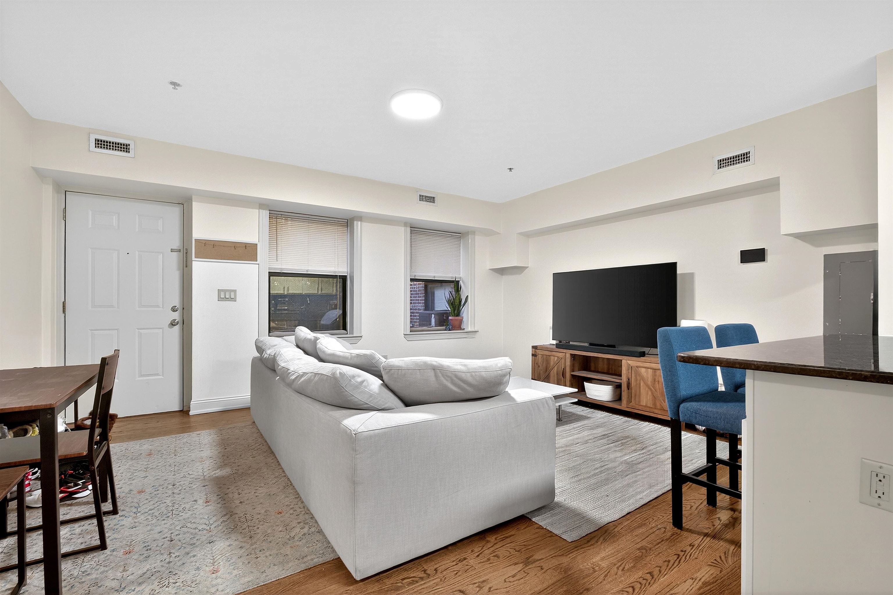 46 Mercer Street, Unit 2 Jersey City, NJ 07302 - Photo 8 of 17 a living room with furniture and a flat screen tv