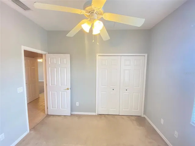 a view of an empty room with a chandelier fan