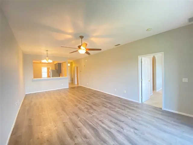 a view of a big room with wooden floor and windows