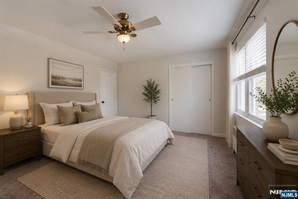 255 Bogert Road, Unit 2A River Edge, NJ 07661 - Photo 13 of 23 a bedroom with a bed chandelier and a window