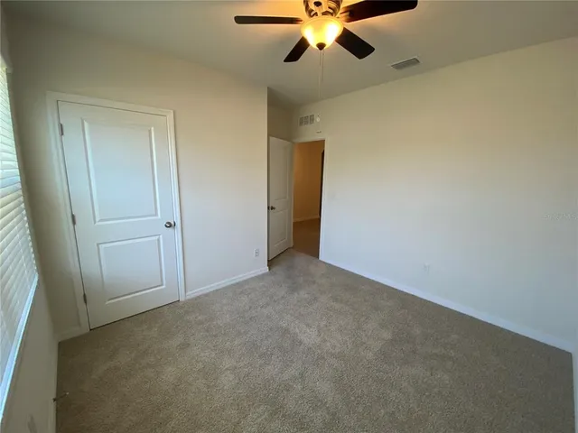 an empty room with a chandelier fan and a chandelier fan