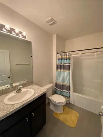 a bathroom with a sink a toilet a mirror and shower