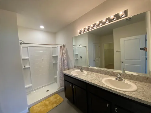 a bathroom with a double vanity sink and a mirror