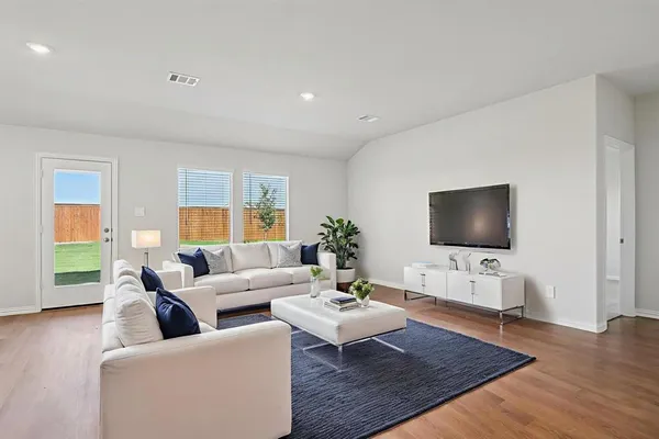 a living room with furniture a flat screen tv and a large window