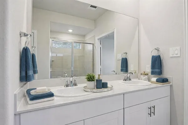 a bathroom with a double vanity sink and a mirror