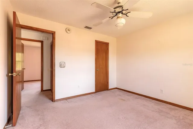 an empty room with ceiling fan and fan