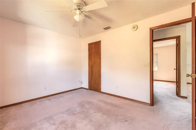 an empty room with a ceiling fan and a window