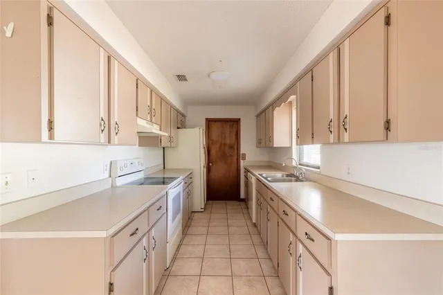a kitchen with a sink stove and cabinets