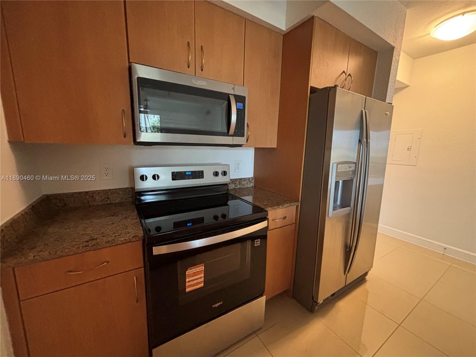 1830 Radius Drive, Unit 318 Hollywood, FL 33020 - Photo 12 of 47 a kitchen with stainless steel appliances granite countertop a refrigerator stove and microwave