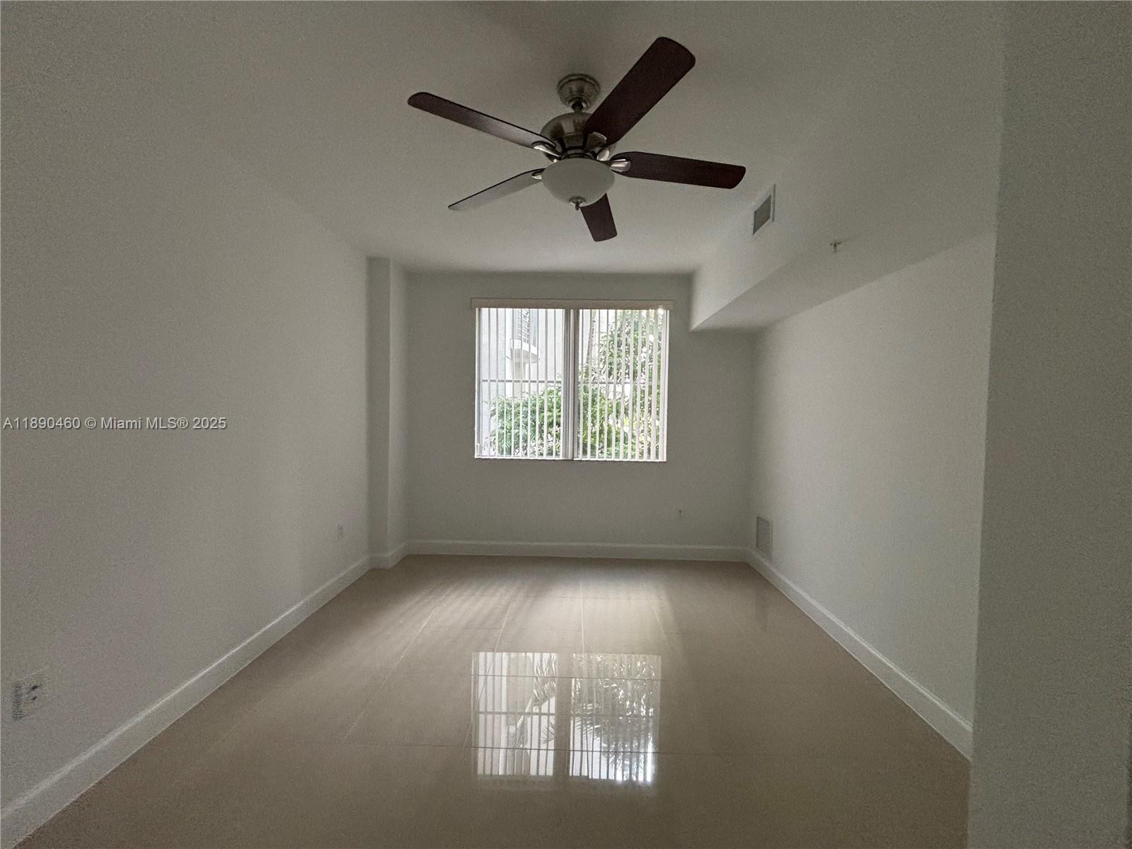 1830 Radius Drive, Unit 318 Hollywood, FL 33020 - Photo 13 of 47 an empty room with windows and ceiling fan