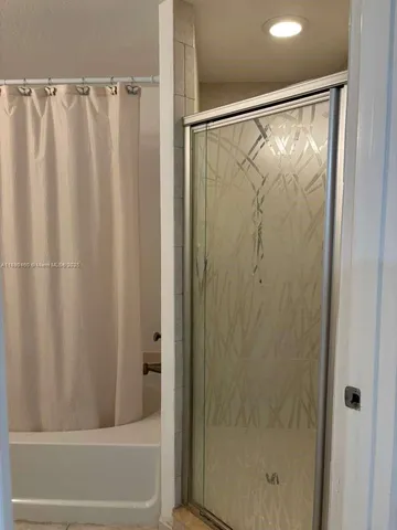 a bathroom with a shower and a bath tub