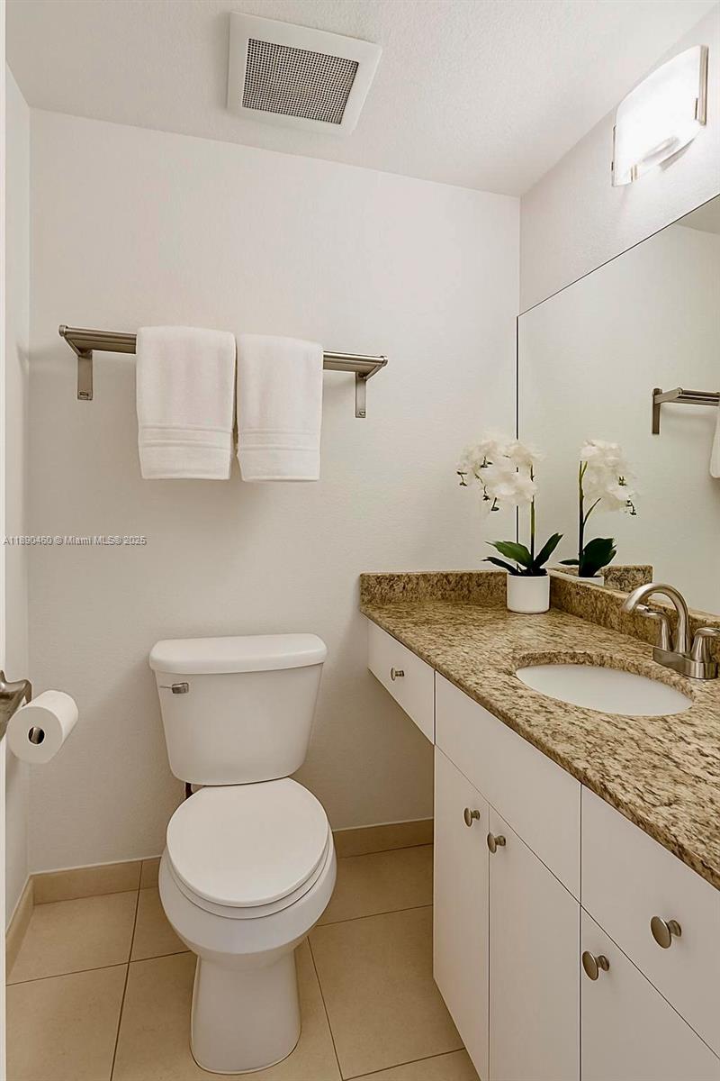 1830 Radius Drive, Unit 318 Hollywood, FL 33020 - Photo 20 of 47 a bathroom with a granite countertop toilet sink and mirror