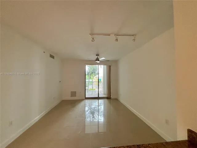 an empty room with windows and cabinet