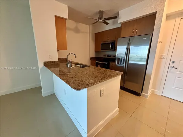 a kitchen with stainless steel appliances granite countertop a sink a refrigerator and a stove