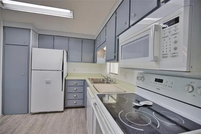 a kitchen with a sink cabinets stainless steel appliances and a window