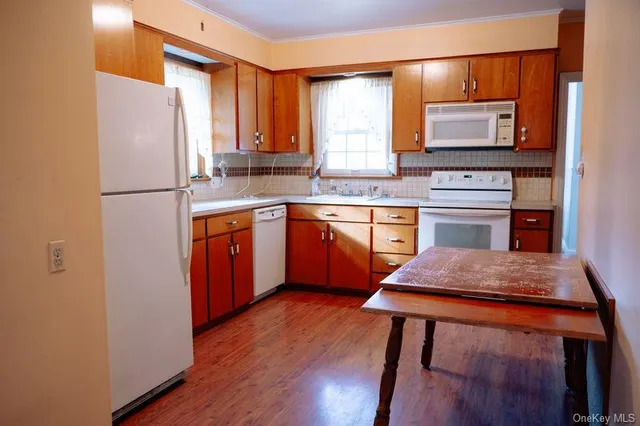 a kitchen with stainless steel appliances granite countertop white cabinets a sink and a refrigerator