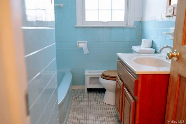 a bathroom with a sink a toilet and a window