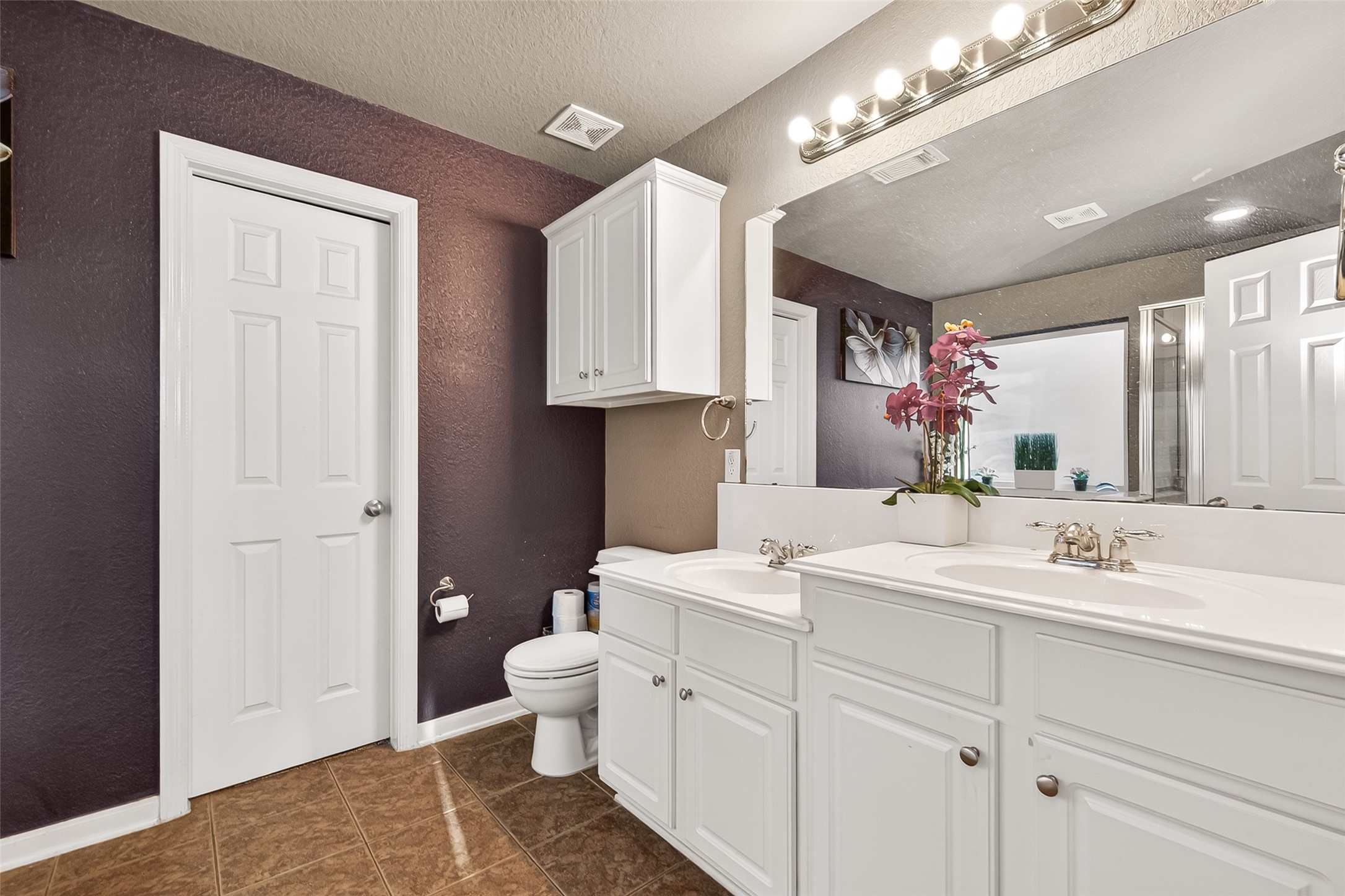 16715 Mackenzie Mesa Drive Spring, TX 77379 - Photo 41 of 50 a spacious bathroom with a toilet sink double vanity and mirror