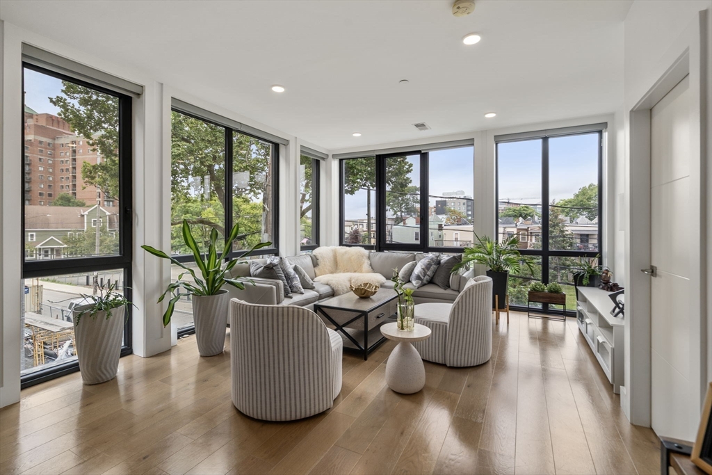a living room with furniture and floor to ceiling windows