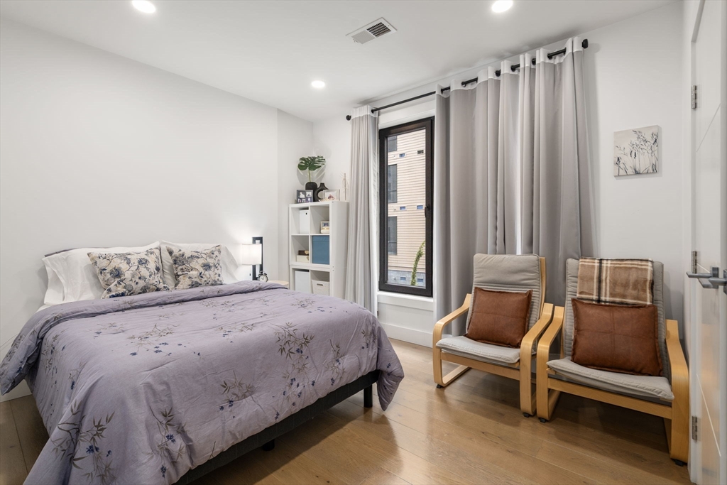 30 Penniman Road, Unit 201 Boston, MA 02134 - Photo 11 of 23 a bedroom with a bed and a chair