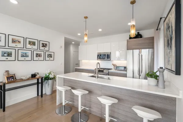 a view of kitchen island with stainless steel appliances furniture refrigerator dining table and chair