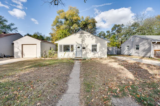 a view of a white house with a yard and large tree
