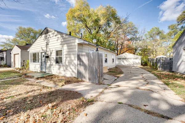 a view of a white house with a yard and a large tree