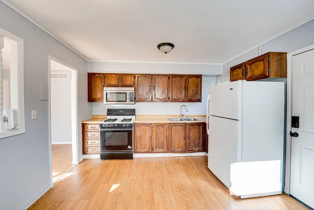 a kitchen with stainless steel appliances a stove a refrigerator and a sink