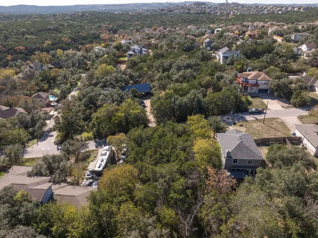 an aerial view of residential houses with city and green space