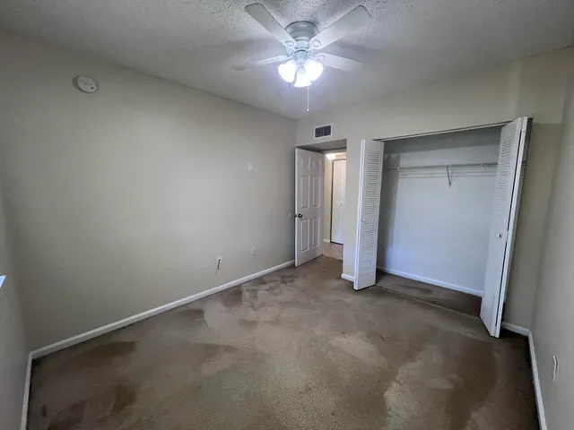 an empty room with a ceiling fan and a window