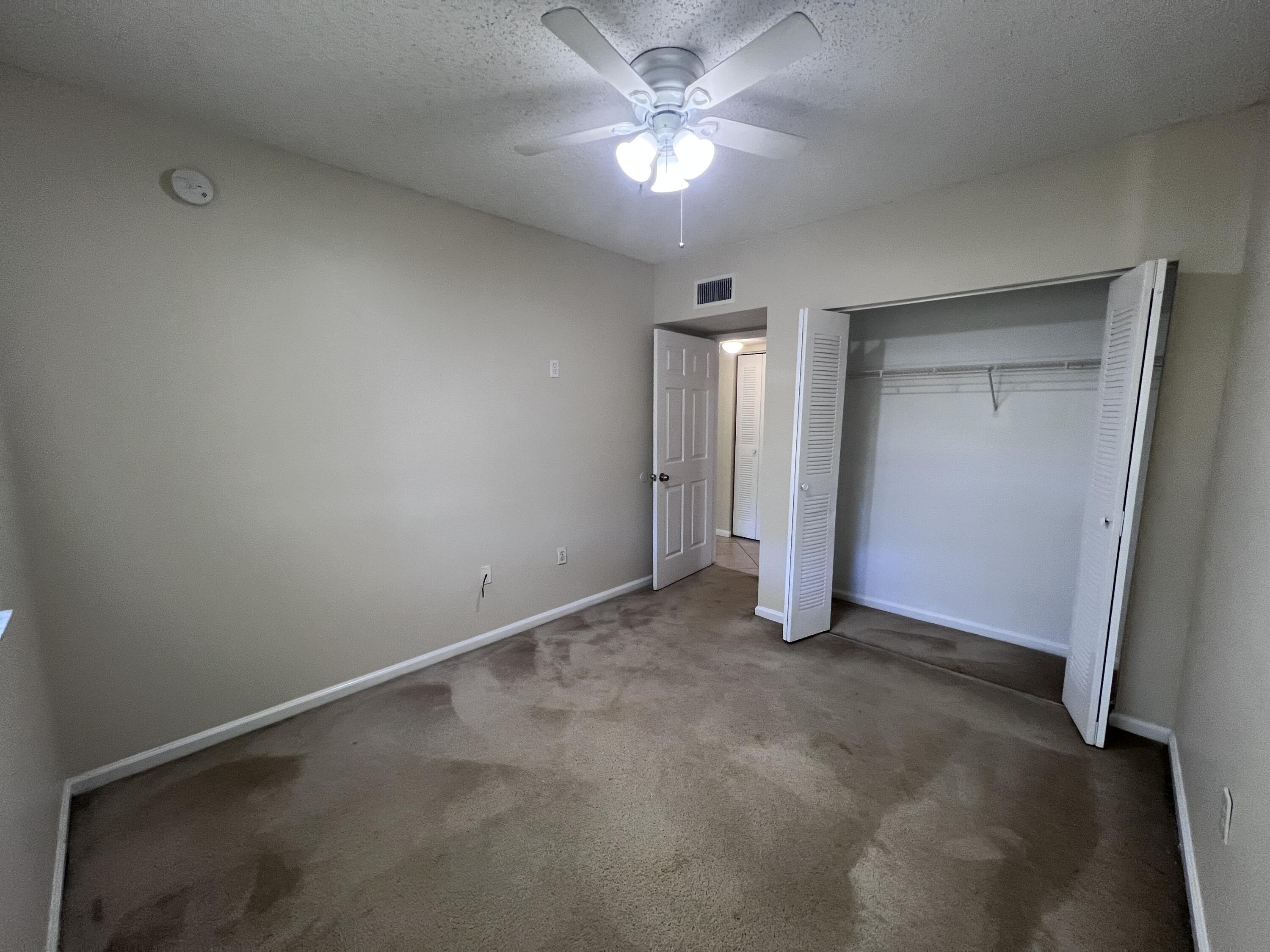 284 Village Boulevard, Unit 9202 Tequesta, FL 33469 - Photo 14 of 16 an empty room with a ceiling fan and a window