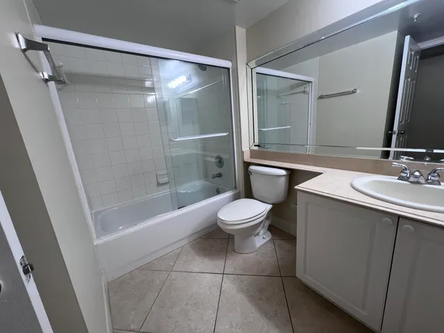 a bathroom with a bathtub shower sink vanity and toilet