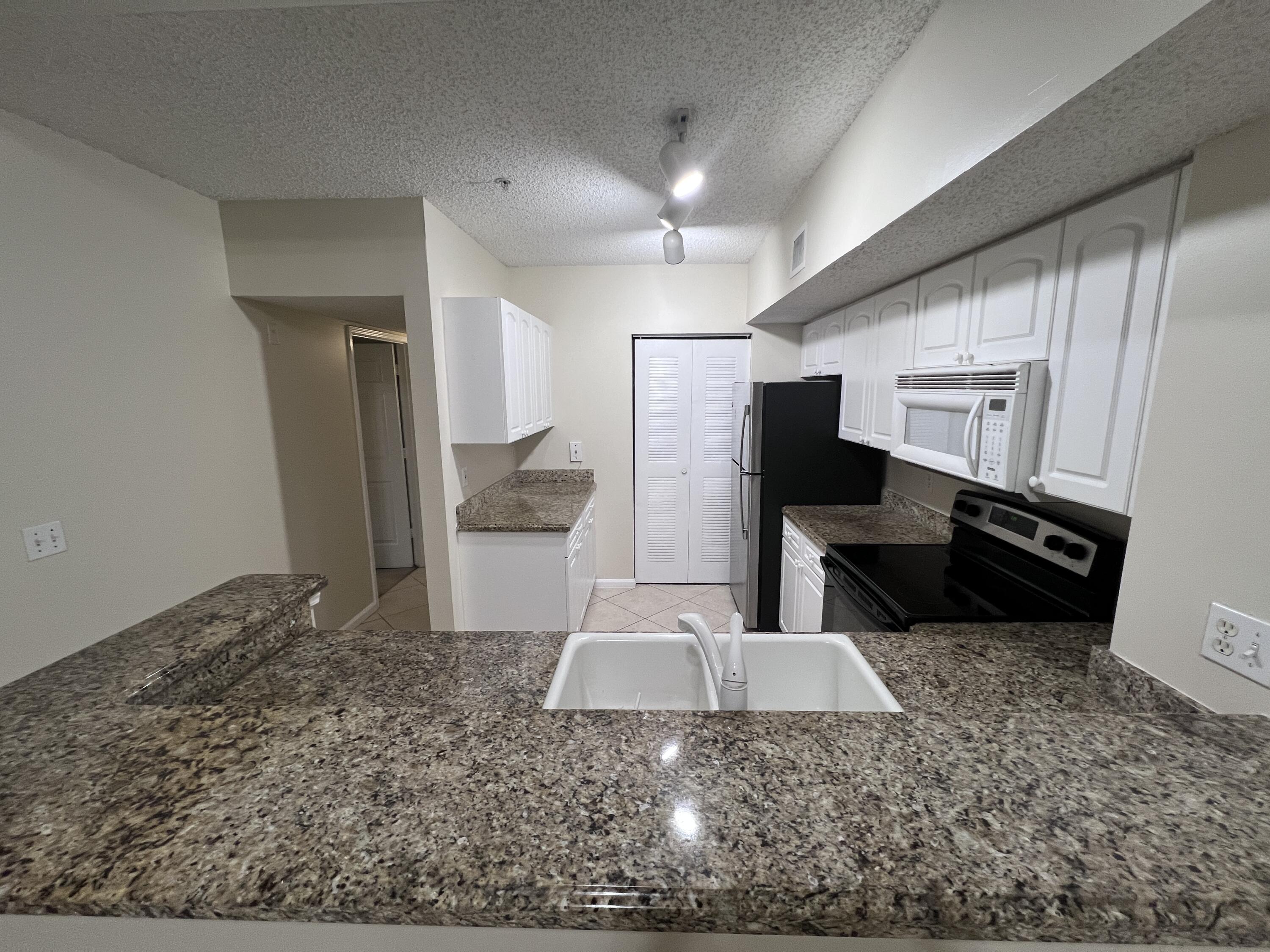 284 Village Boulevard, Unit 9202 Tequesta, FL 33469 - Photo 7 of 16 a view of a refrigerator in kitchen and living room